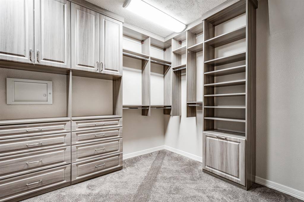 Spacious primary bedroom closet with elegant custom-built storage solutions.