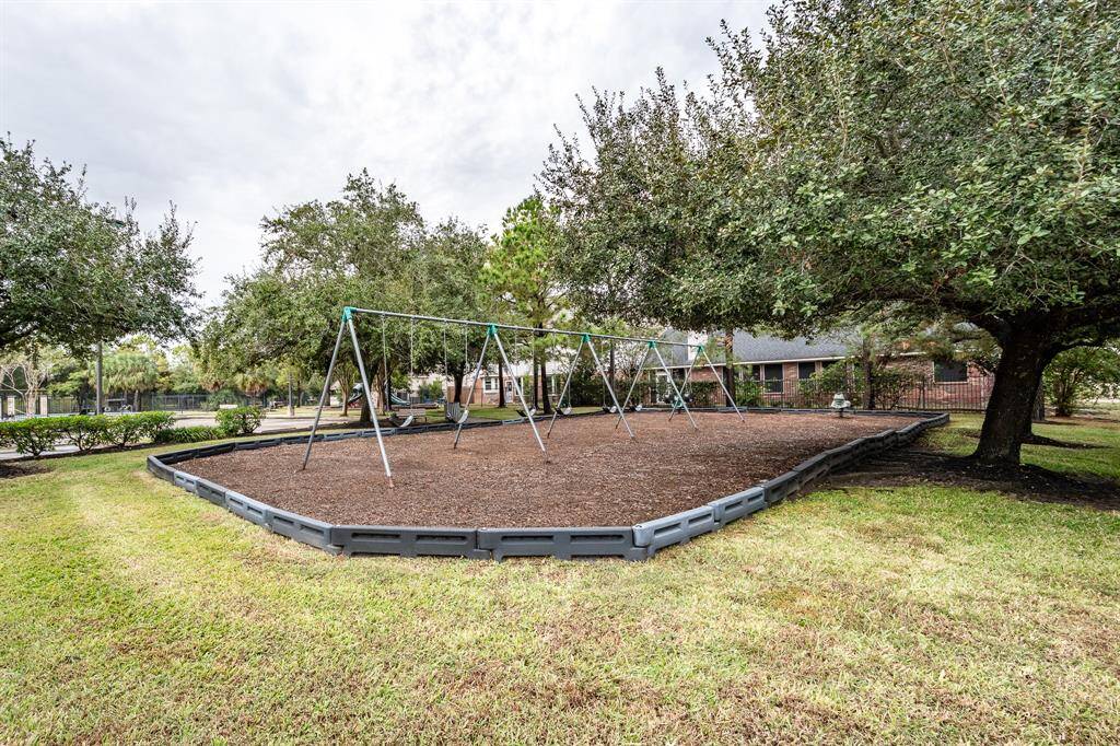 Charming community playground adjacent to the pool area.