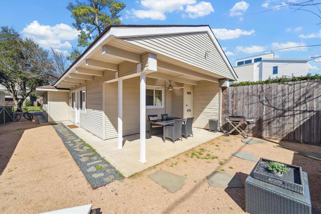 Covered outdoor patio space with the necessary fan plus a crushed stone covering the outdoor living space.