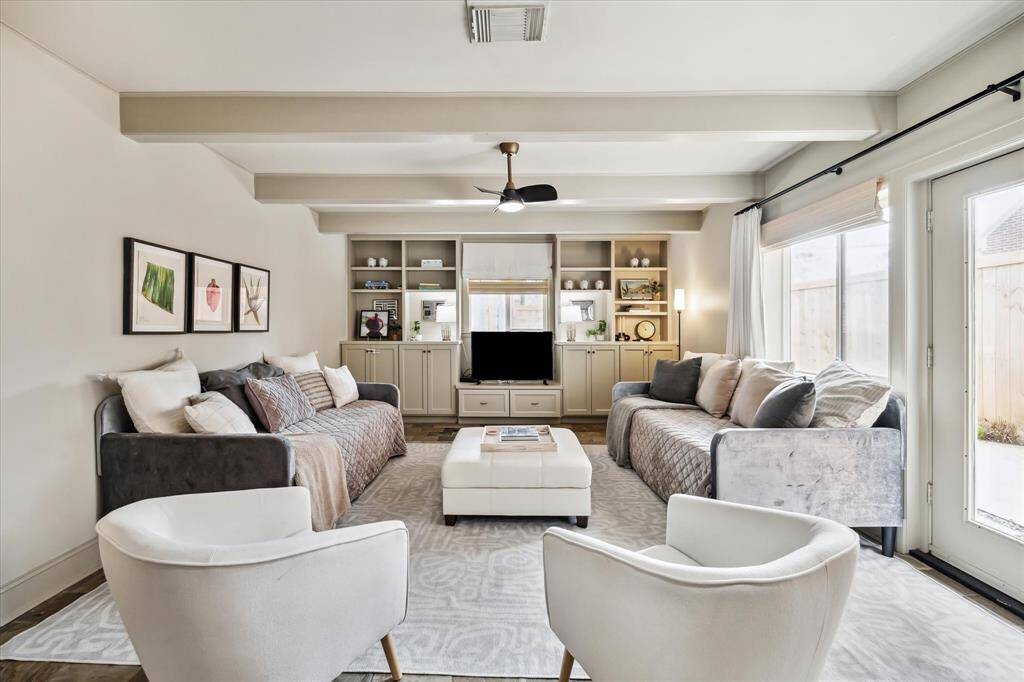 What living/family room doesn't love a wall of built-ins! Lots of natural light as well.