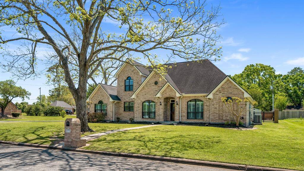 Look at the well-maintained lawn and mature tree in the front yard. The house features a steeply pitched roof, arched windows, and a welcoming front entrance. It's situated on a quiet street, offering a serene and inviting atmosphere.