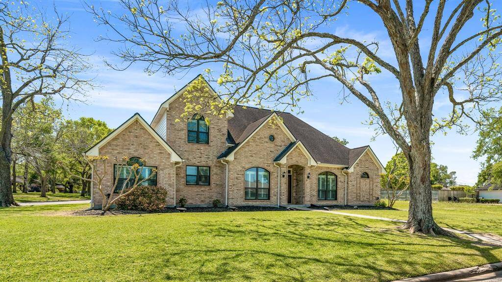 Majestic home situated on a spacious, well-manicured lawn with mature trees, offers a serene and inviting atmosphere.