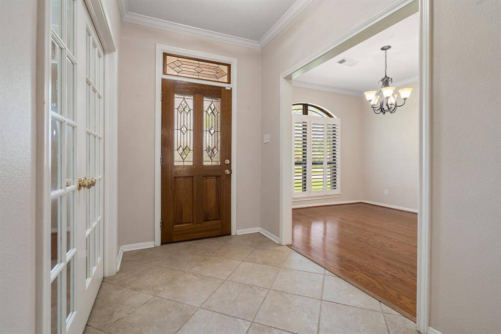 Entryway features a wooden front door with decorative glass, stain glass transom above the door and tile flooring!