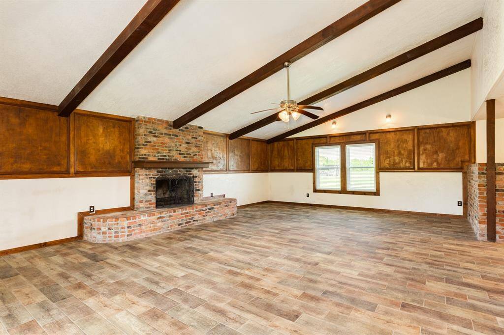 Living Area Features Wood Burning Fireplace and Beamed Ceiling