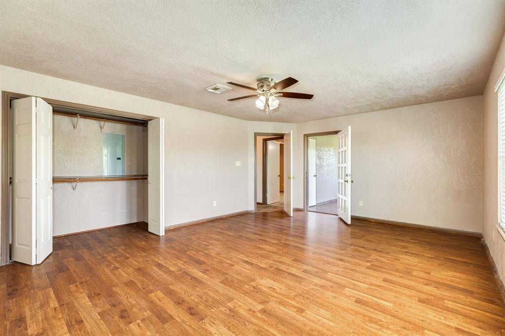 This view of the Primary Bedroom shows the closet to the left and the door to the Sunroom straight back on the right. Primary Bedroom is approximately 19'2" x 14'8". Buyer to verify all room measurements.