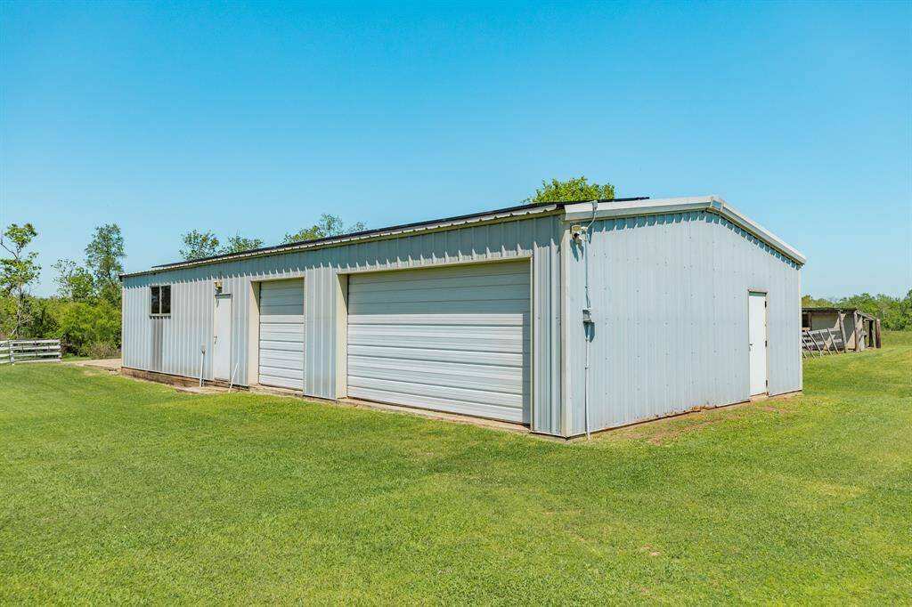 This shop/workshop/garage/building has space for 3 vehicles and two separate walk-in entrances. It also has a large concrete pad on the side of the building, which was used as a patio with elevated vegetable planters and a container flower garden.