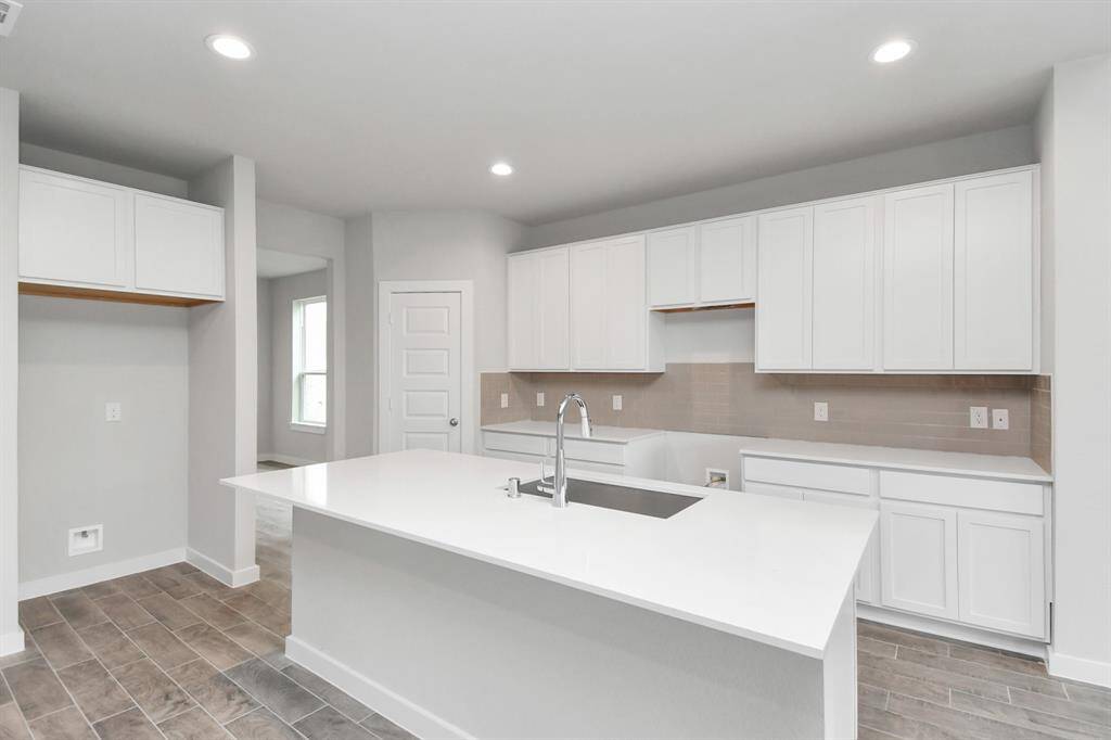 Revel in features in this kitchen like a massive granite island, high ceilings, soft-close cabinets, quartz countertops. Sample photo, actual color and selections can vary.