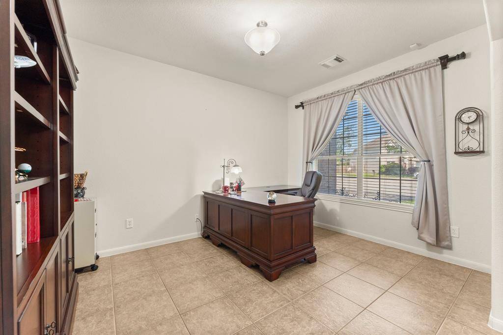 The spacious front office offers versatility with elegant tile flooring—perfect as a dedicated workspace or a formal sitting area filled with natural light.