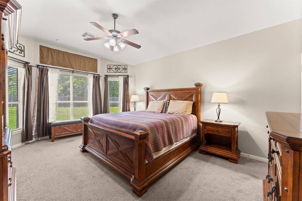 Bathed in natural light from multiple windows, this expansive primary bedroom offers a serene retreat with space to relax, recharge, and unwind in style.