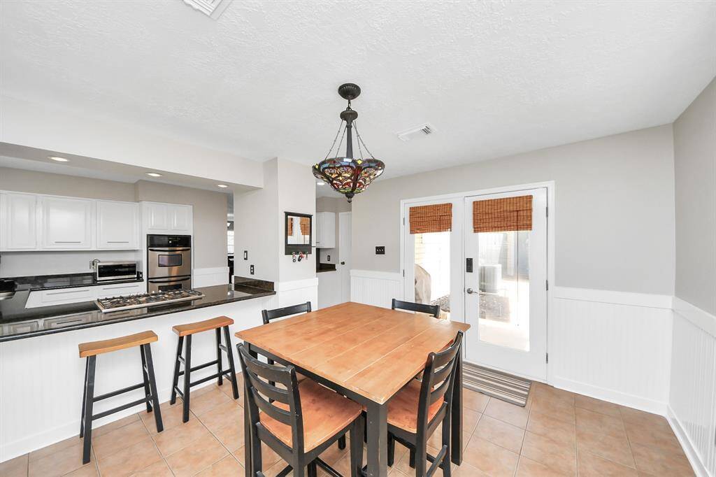 Glass doors open directly to the driveway area, offering added convenience for unloading groceries and everyday errands.