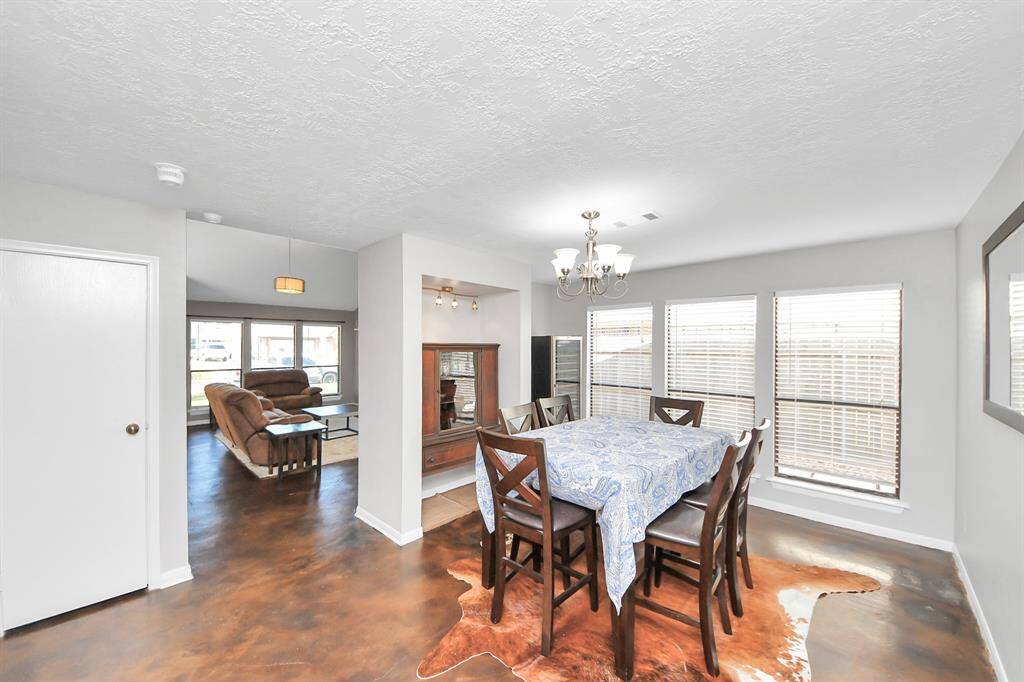 The light-filled dining area offers the perfect setting for gatherings, with a wall of windows providing abundant natural light. An inset nook creates a stylish space for a buffet or display cabinet, adding charm and functionality.