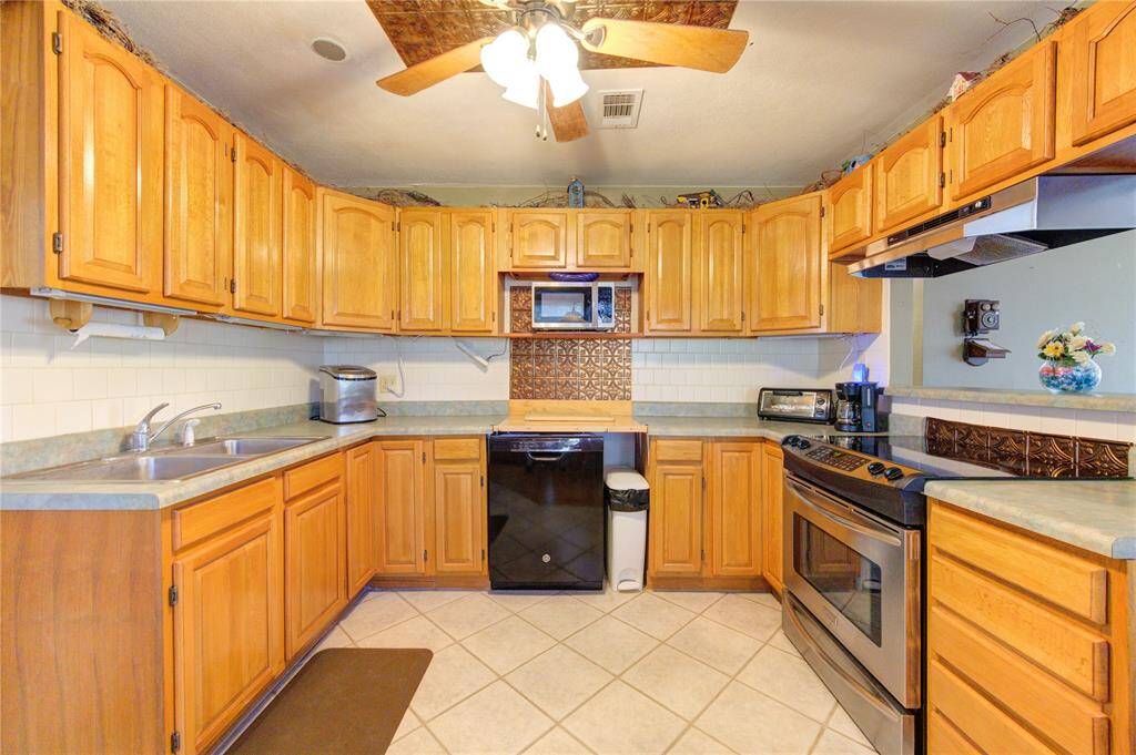 Charming kitchen with warm wood cabinetry, modern appliances and recessed lighting.
