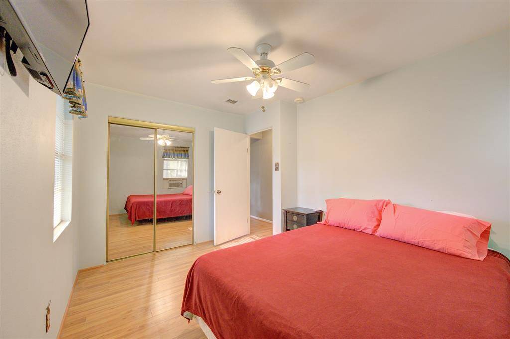 Primary bedroom with ample natural light and hardwood floors, offering a serene retreat.