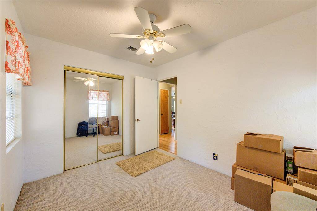 Charming Guest Bedroom with Ample Natural Light and Spacious Closet.