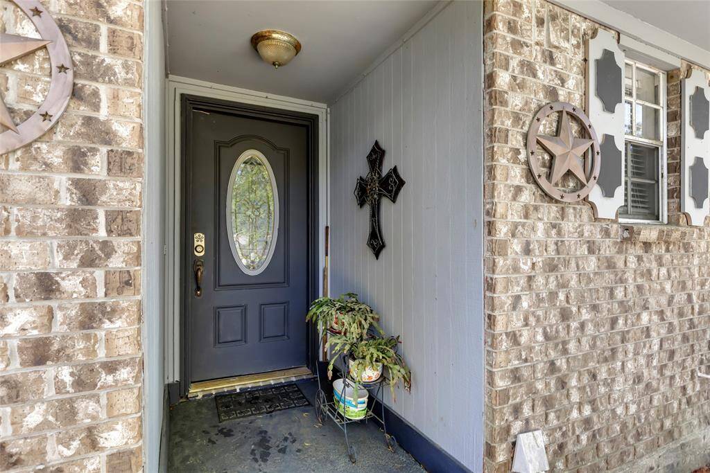 Charming front entrance with a decorative black door featuring an oval glass insert.