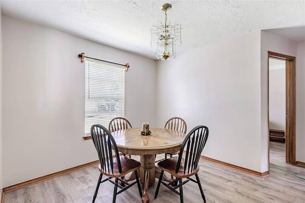 The dining area has neutral walls and wood-look flooring, offering a warm and inviting atmosphere.