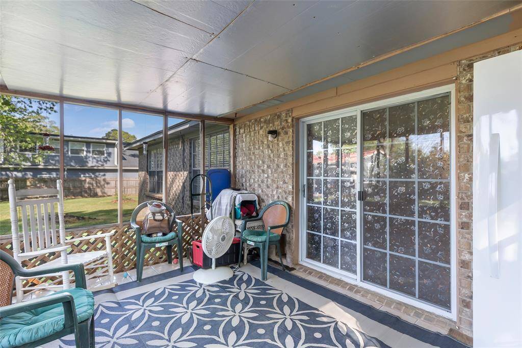 This photo showcases a sunroom with sliding glass doors. It offers a bright space with a view of the yard, perfect for relaxation or entertaining.