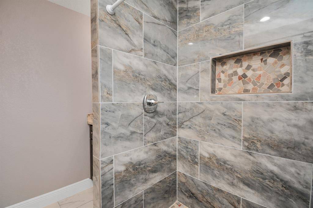 Guest restroom is surrounded by ceramic tile