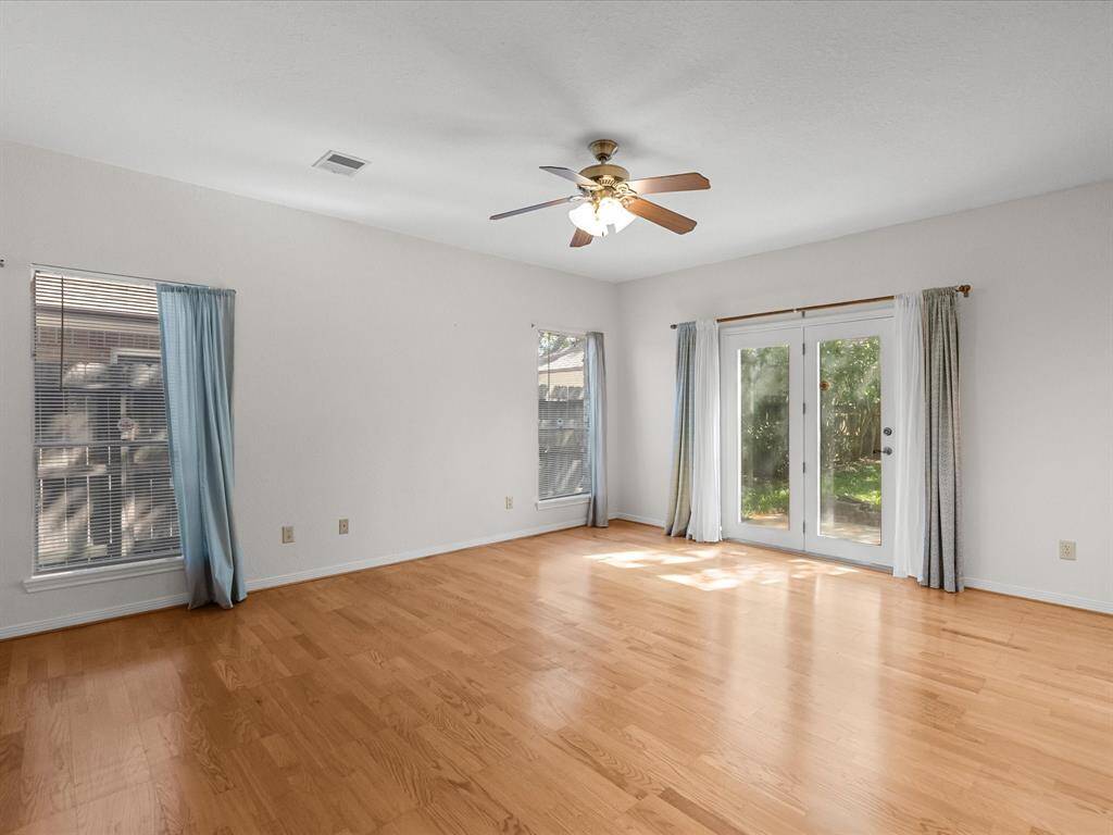 Spacious primary retreat with wood floors, natural light, and private patio access.