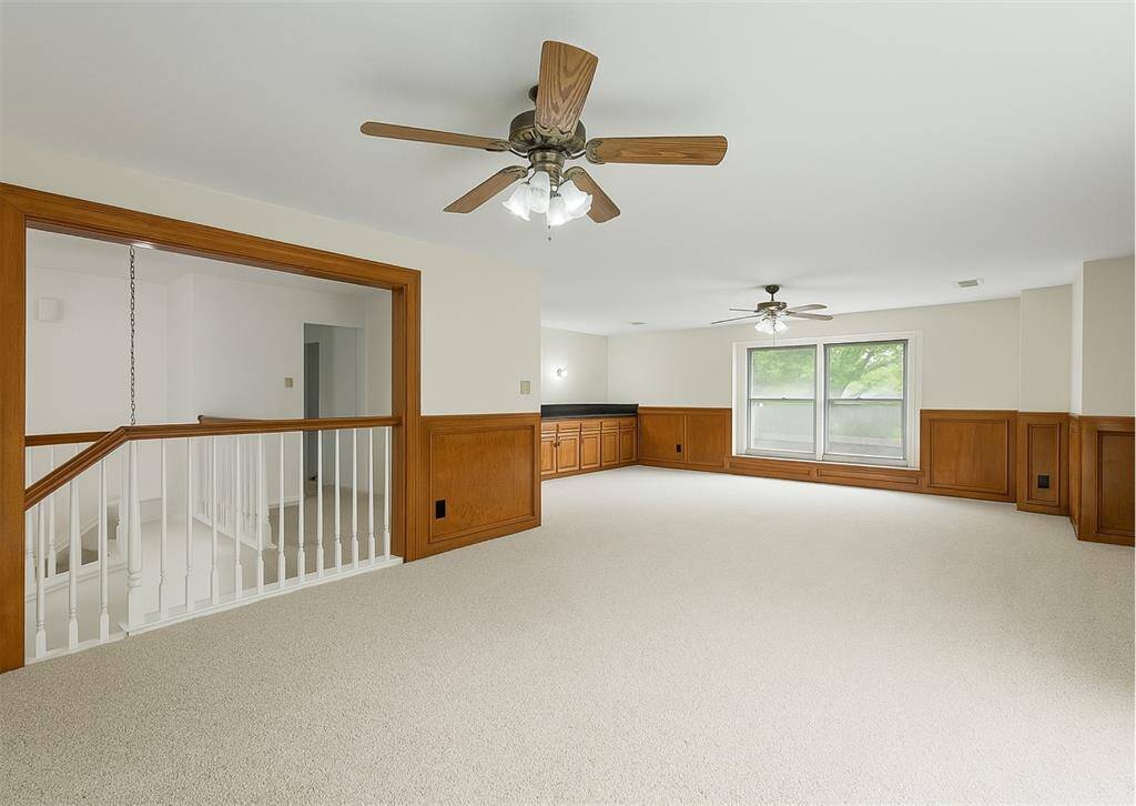Oversized game room or second living area with wood accents and built-in cabinetry.