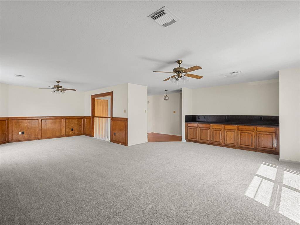 Oversized game room or second living area with wood accents and built-in cabinetry.