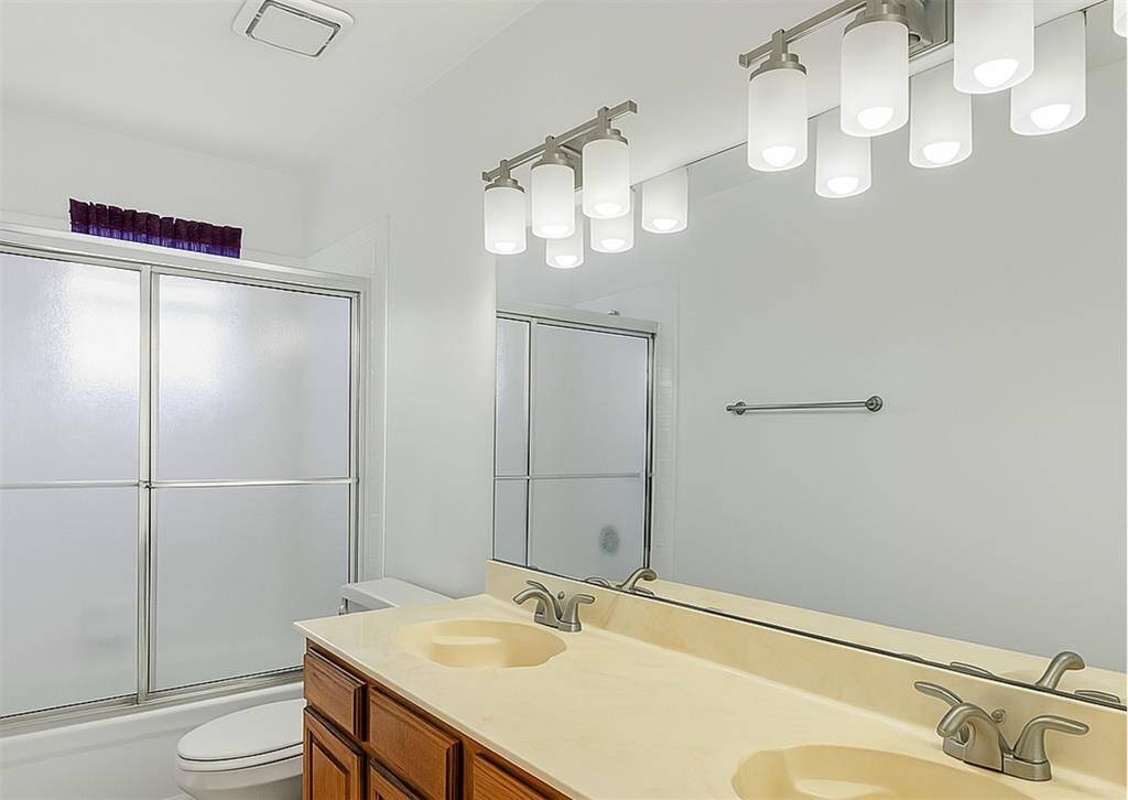 Secondary full bath with dual sinks and tub/shower combo—perfect for shared space.