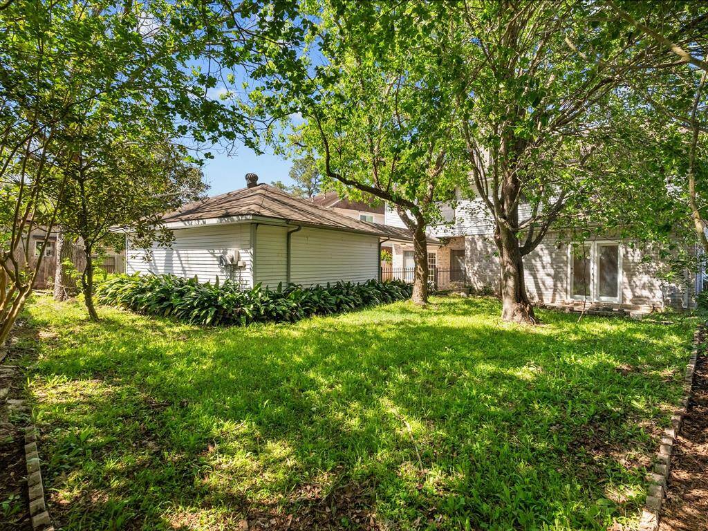 Generous backyard with mature trees, detached garage view, and endless potential for entertaining.