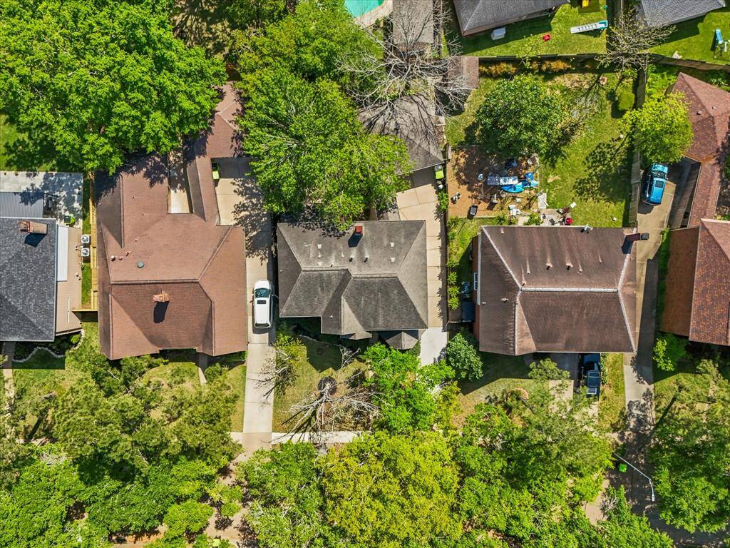 Aerial view showcasing lot layout, detached garage, and private driveway access.