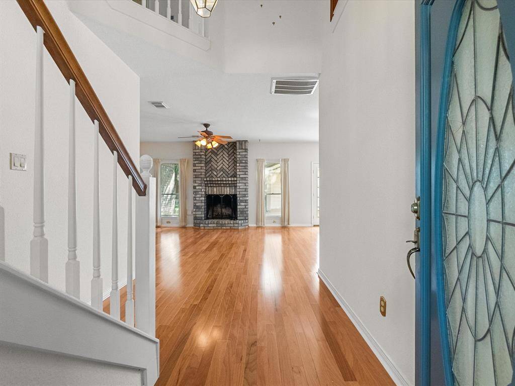 Welcoming entry with wood flooring and a direct view into the open living room and fireplace.