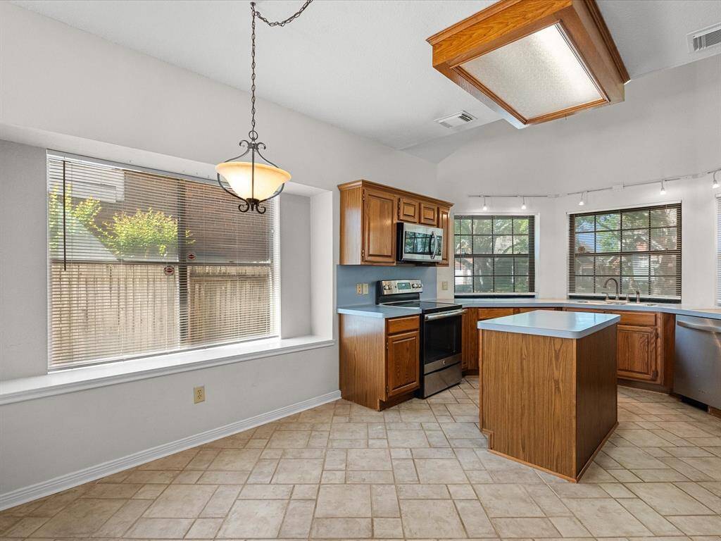 Bright kitchen with breakfast nook, bay window seating, and wraparound counters for meal prep ease.