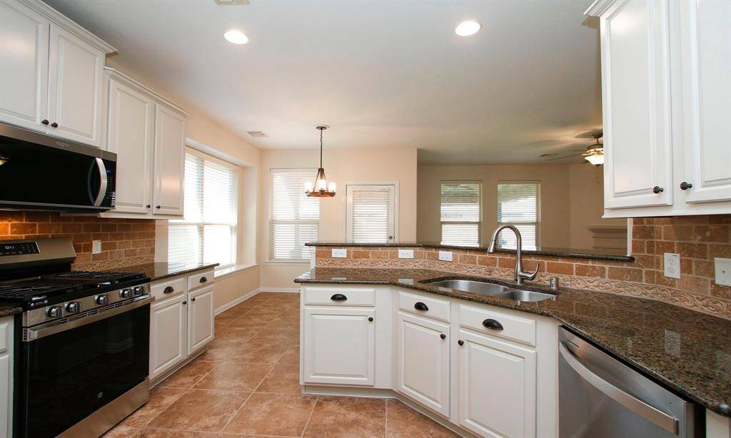The Kitchen Features Refinished Cabinets, Granite Counters, Travertine Back Splash With Accent Border, Under-Mount Sink, And Recessed Lights.