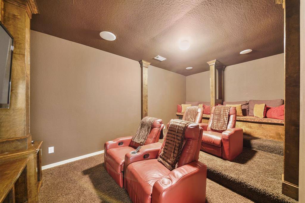 Cozy home theater with warm lighting and carpeted floors create an inviting atmosphere for movie nights.