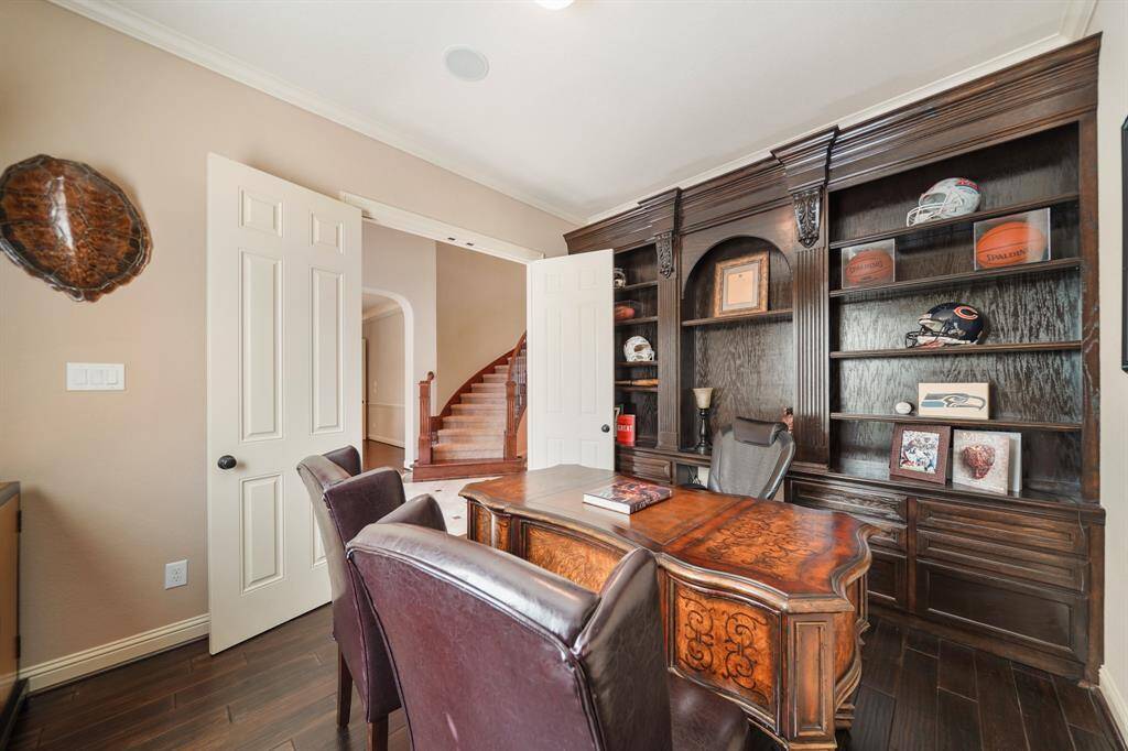 Here's another view of the home office which features elegant wood flooring, built-in shelving, and a large window for natural light.