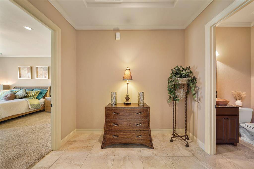 Discover a charming hallway with elegant tile flooring, perfectly situated between the primary bedroom and bathroom.