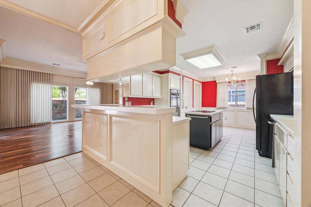 Bright kitchen flows beautifully to a spacious living area with wood floors and large windows overlooking the patio. Perfect for entertaining.