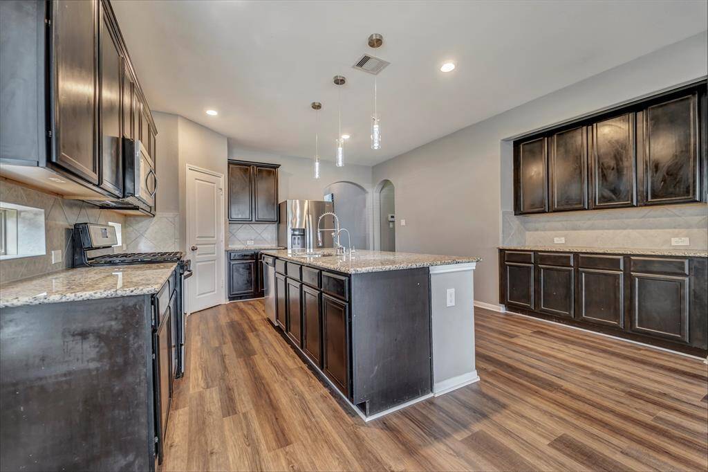 This photo shows the kitchen with the butler pantry. Penchant lighting with granite counter tops. Reverse osmosis gives you great tasting water!