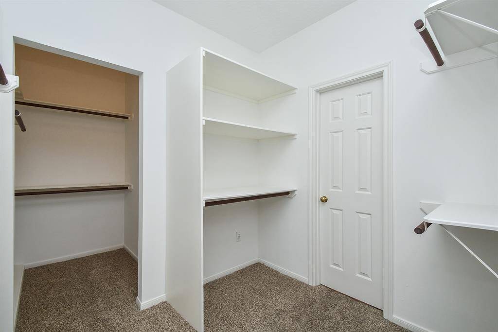 This photo showcases a spacious walk-in closet with ample shelving and hanging space.