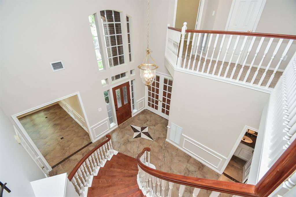 Elegant view of the grand entryway from the second floor, showcasing stunning architecture and welcoming natural light.