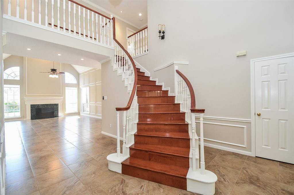 Elegant two-story foyer with a stunning curved staircase leading to the second floor.