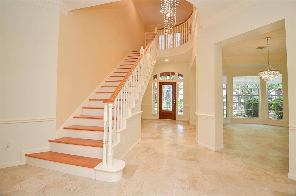 View of the staircase, elegant chandelier, foyer and formal dining room