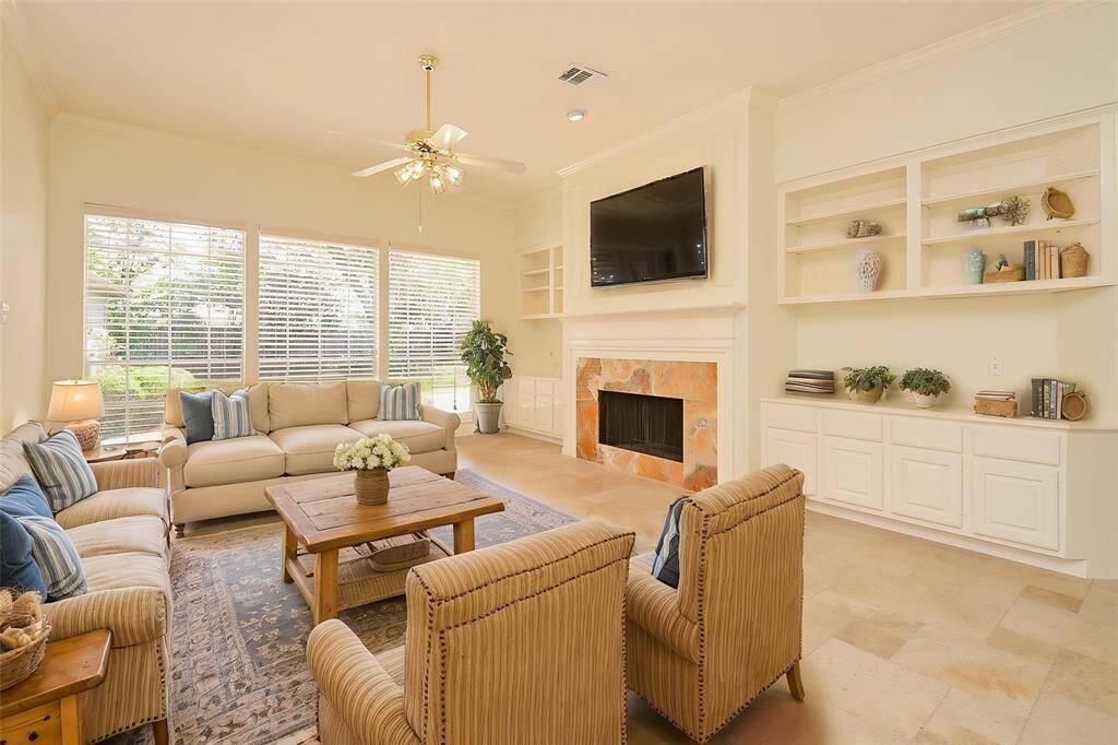 Family room with large windows for natural light, fireplace and built ins*virtually staged*