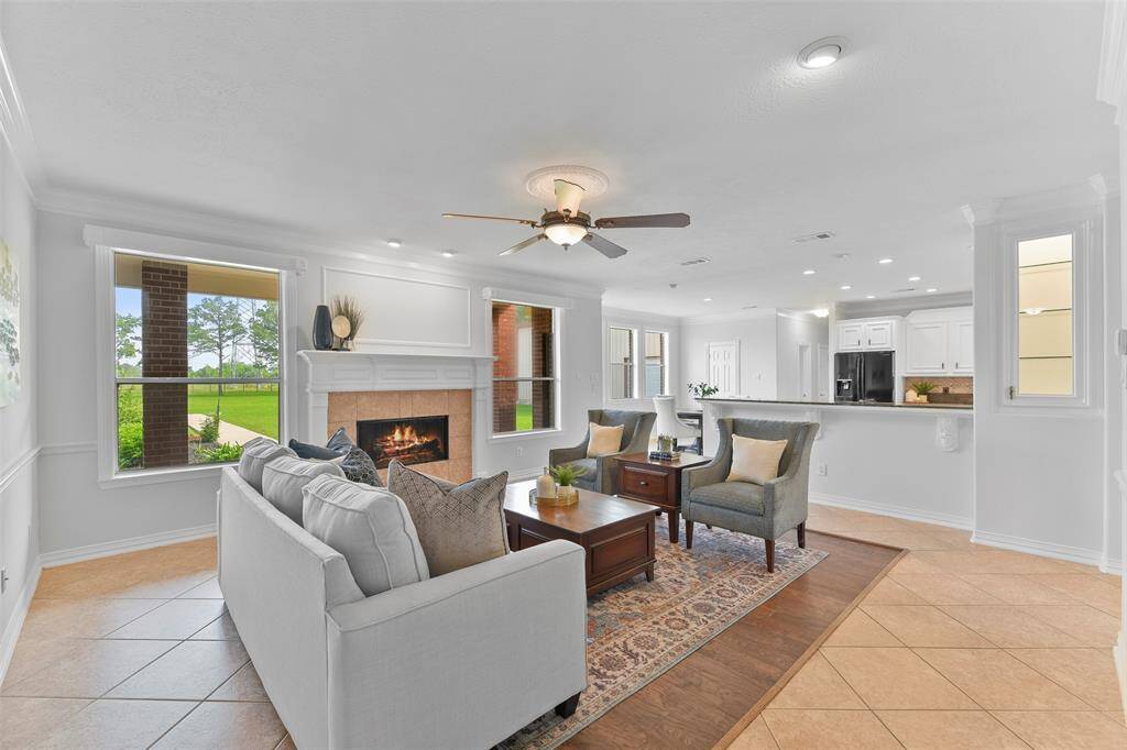 At the heart of the home, find a spacious family room with fresh neutral paint, diagonally laid ceramic tile floors, recessed lighting, a lighted ceiling fan, and a gas log fireplace flanked by beautifully cased rear-facing windows.