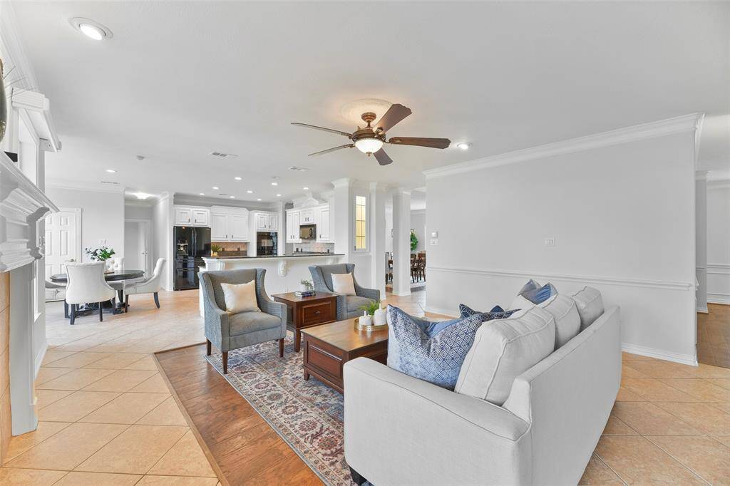 This view of the family room helps to visualize the flow of the floorplan with the formal living room and study off of the corridor on the right, the dining room and foyer opposite that, and a seamless transition into the adjoining breakfast room and island kitchen.