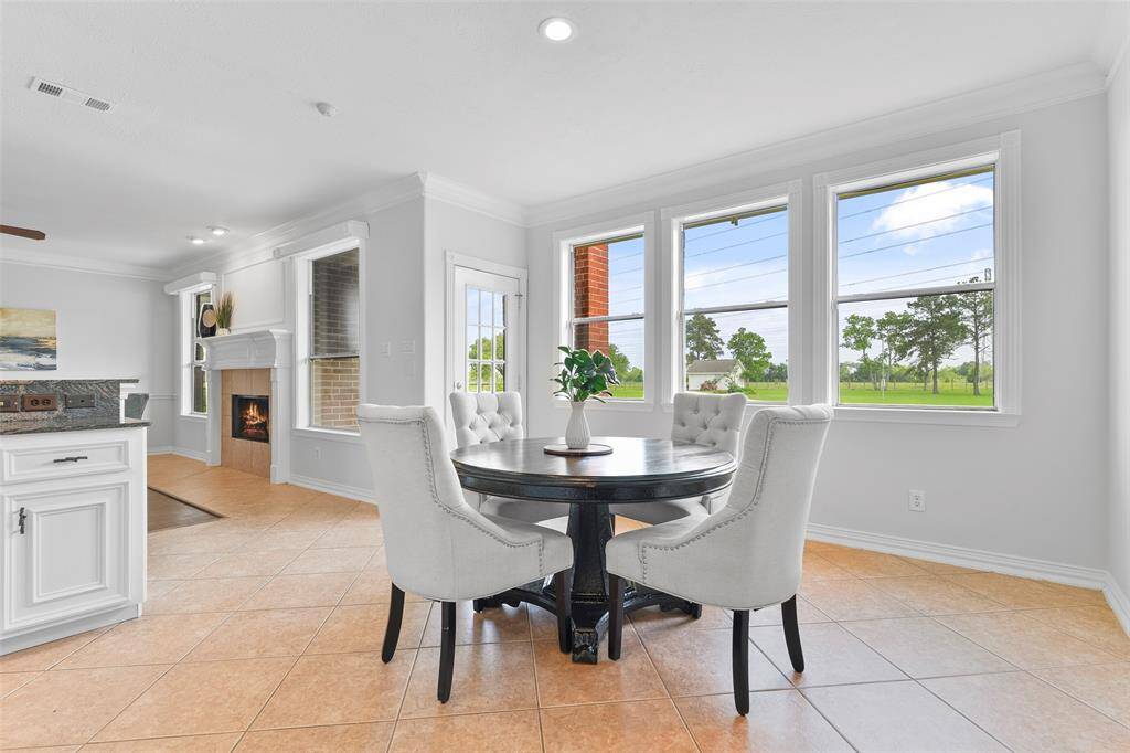 Enjoy a casual meal or your morning coffee here, in the sunlit eat-in breakfast room that is located just off of the family room and kitchen. Note the fresh neutral paint, recessed lighting, easy maintenance tile floors, and windows with acreage views behind the home.