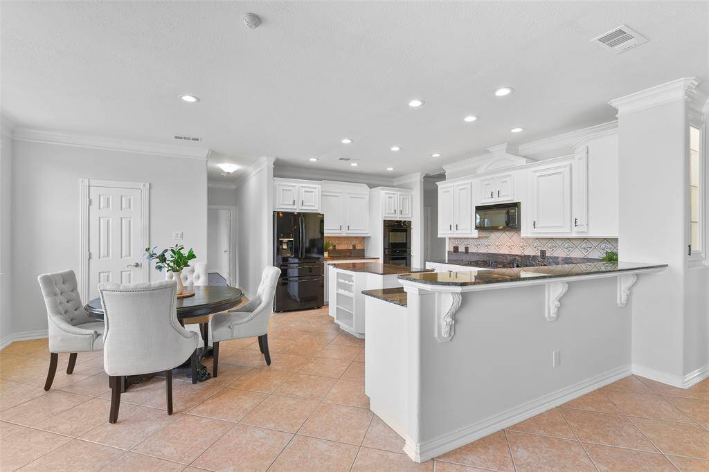 Enjoy a casual meal or your morning coffee here, in the sunlit eat-in breakfast room that is located just off of the family room and kitchen. Note the fresh neutral paint, recessed lighting, easy maintenance tile floors, and windows with acreage views behind the home.