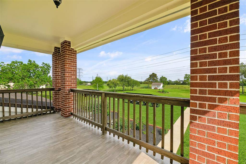 French doors open from the second-floor living space onto this rear-facing balcony with peaceful views of the acreage beyond the home as well. A utility easement is located behind the property, which means no rear neighbors!