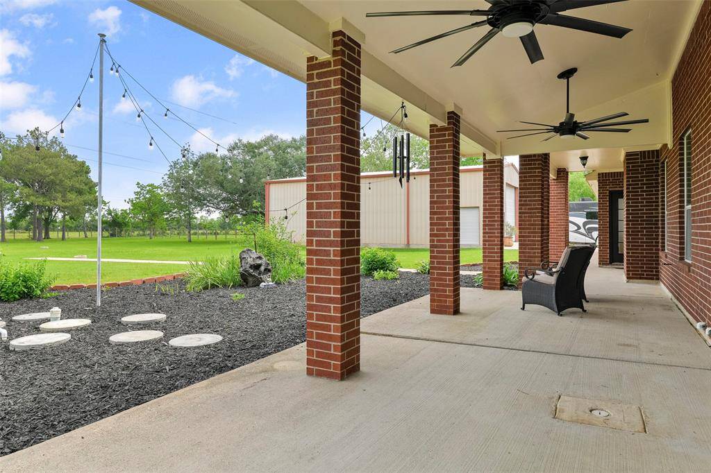 Relax and enjoy your morning coffee and a cool breeze from a pair of outdoor grade ceiling fans on this expansive covered patio overlooking the well-maintained landscaping and lush acreage behind the home. It's so peaceful out here!