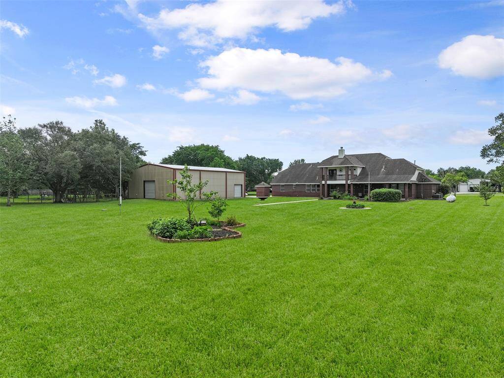 A glance from the rear corner of the property highlights much of what this home has to boast about - unrestricted acreage with a HUGE metal building and a freshly painted, beautifully updated, and incredibly spacious home that includes THREE new zoned A/Cs!