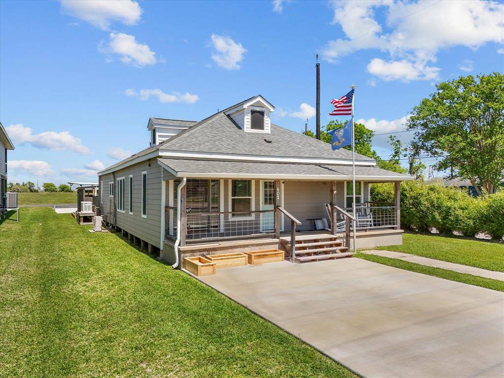 Charming single-story home with a welcoming front porch, well-maintained lawn, and a spacious driveway. Ideal for comfortable living with outdoor space for relaxation.