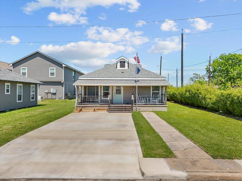 This charming home features a welcoming front porch with rocking chairs, a neat lawn, and a spacious driveway. The exterior is well-maintained, and the house has a classic, cozy appeal. Ideal for those seeking a comfortable and inviting home.